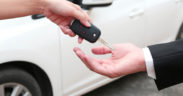 A person hands over car keys during a vehicle handoff